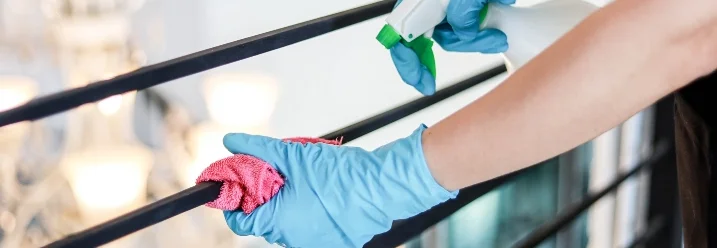 Person reinigt Geländer mit Lappen